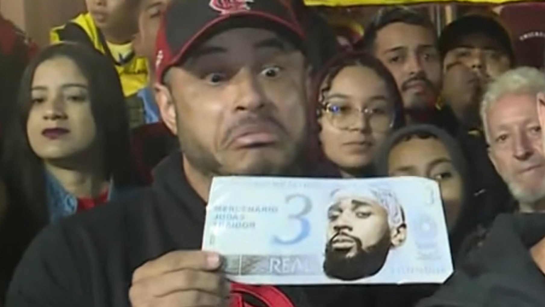 Torcedor do Flamengo segura nota de 3 reais com o rosto de Gerson durante o 'AeroFla'